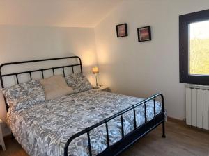 a bedroom with a bed and a window at La Perle Rare in La Barthe