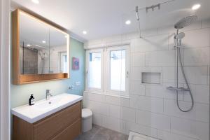 a white bathroom with a sink and a shower at Modernes Ferienhaus Dornbirn mit 2 Schlafzimmern 2 Bädern nahe Bodensee & Bregenzerwald in Dornbirn