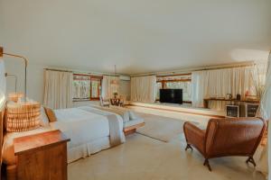 a large bedroom with a bed and a television at Reserva Jacumã Boutique Hotel in Trancoso