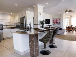 a kitchen with a large island with two bar chairs at Rondevoux 17 in Margate