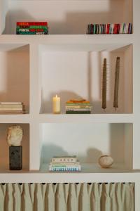 a white shelf with books and candles on it at Hotel Can Sastre in Santa Gertrudis de Fruitera
