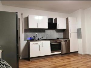 a kitchen with white cabinets and stainless steel appliances at Ferienwohnung am Bahnhof Schwerte mit Balkon in Schwerte