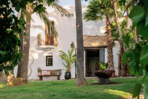 a house with palm trees in the yard at Hotel Can Sastre in Santa Gertrudis de Fruitera