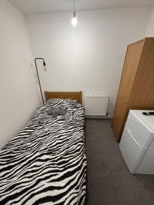 a bedroom with a zebra print bed and a dresser at Serenity LTD in Leicester