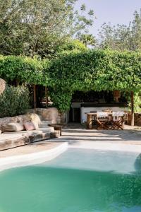 an outdoor patio with a table and a swimming pool at Hotel Can Sastre in Santa Gertrudis de Fruitera