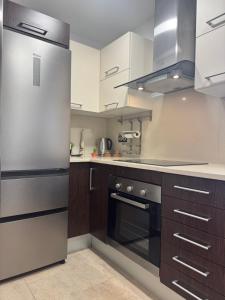a kitchen with wooden cabinets and stainless steel appliances at Suitte Catalunya in Calafell
