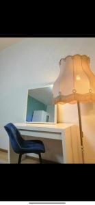 a desk with a blue chair and a lamp at Ferienwohnung am Bahnhof Schwerte mit Balkon in Schwerte +5 photos
