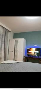 a bedroom with a bed and a flat screen tv at Ferienwohnung am Bahnhof Schwerte mit Balkon in Schwerte