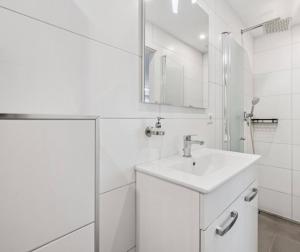 a white bathroom with a sink and a mirror at Prime Host Dream Deluxe in Karlsruhe