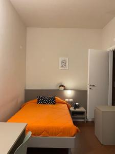 a bedroom with an orange bed with a black and white pillow at Locanda La Cavallina in Brisighella +99 photos