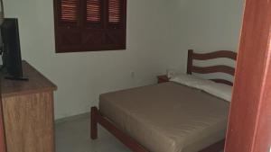 a bedroom with a bed and a wooden chair at Paraíso dos Falcões in Nísia Floresta +31 photos