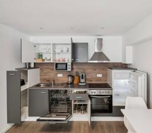a kitchen with stainless steel appliances and white cabinets at Prime Host Dream Deluxe in Karlsruhe