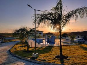 a couple of palm trees in front of a house at Paraíso dos Falcões in Nísia Floresta