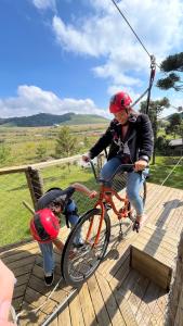 a woman riding a bike with a child on it at Parador Pôr do Sol in Cambará