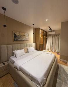 a bedroom with a large white bed in a room at Premium 2 Bedroom Maisonette with Ps5 & Pool in Lekki