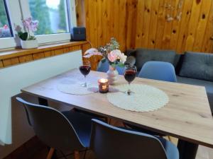 a wooden table with two glasses of red wine at Chatka u Goni Camp przy SUNTAGO in Grabce