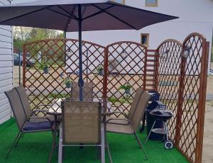a table and chairs under an umbrella on a patio at Chatka u Goni Camp przy SUNTAGO in Grabce