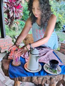 a young girl sitting at a table with a tea pot at Villa Jucumarini in Coroico