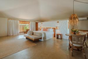 a bedroom with a bed and a couch and a table at Reserva Jacumã Boutique Hotel in Trancoso +33 photos