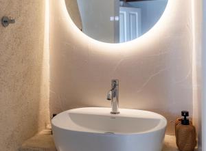 a white sink in a bathroom with a mirror at White Pearl Mykonos in Mikonos +136 photos