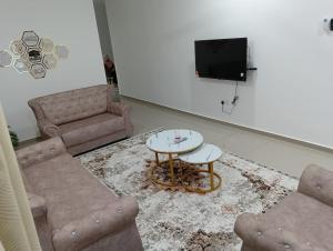 a living room with a couch and a table and a tv at SD Homestay in Bachok