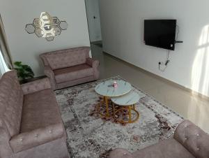 a living room with a couch and a table and a tv at SD Homestay in Bachok +8 photos