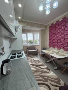 ein Wohnzimmer mit einem Tisch und einer Küche in der Unterkunft Flora in Chişinău