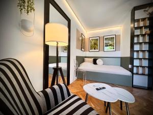a room with a bed and a chair and a table at Apartamenty Młyńska 3A in Gliwice