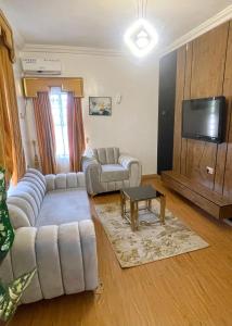 a living room with couches and a flat screen tv at Montevar Hotel in Benin City