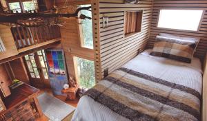 einen Blick über ein Schlafzimmer in einem Blockhaus in der Unterkunft La Casa Del Árbol De Chiloé in Castro