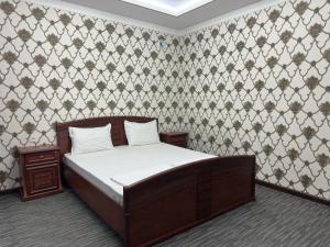 a bedroom with a bed and a wall at Art Angren Hotel in (( Sotsgorod ))