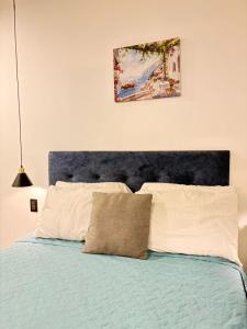 a bed with a blue headboard and two pillows at Eon 2 - Apartamento en edificio con piscina in Estación Pamplona +64 photos