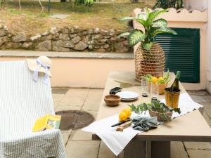 a table with a plate of fruit and a potted plant at Orizzonte Blu - HelloElba in Marciana Marina