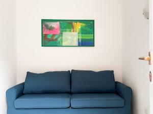 a blue couch in a room with a painting on the wall at Orizzonte Blu - HelloElba in Marciana Marina