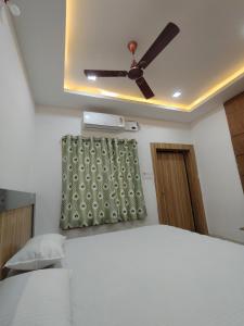 a bedroom with a ceiling fan and a bed at Anand palace lodge in Ghatgān