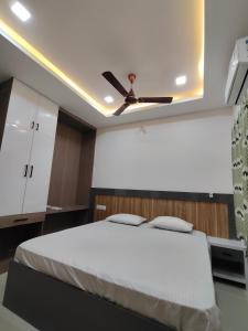 a bedroom with a bed with a ceiling fan at Anand palace lodge in Ghatgān