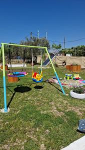 a group of swings on the grass in a park at Lingo garden house in Nea Irakleia