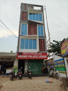a tall building with motorcycles parked in front of it at Anand palace lodge in Ghatgān