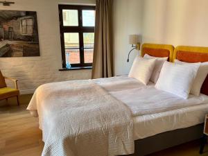 a bedroom with a bed with white sheets and a window at ToRUŃ ApartHotel z widokiem na Wisłę i Krzywą Wieżę in Toruń +196 photos