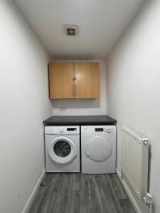 a laundry room with a washing machine and a washer at Serenity LTD in Leicester