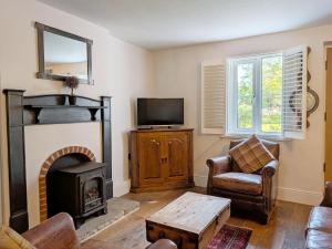 a living room with a fireplace and a tv at Springwell , West Wittering in West Wittering