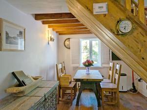 a dining room with a table and a clock on the wall at Springwell , West Wittering in West Wittering