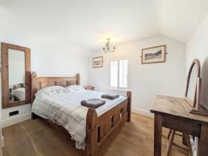 a bedroom with a bed and a table and a mirror at Springwell , West Wittering in West Wittering