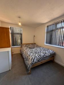 a zebra print bed in a room with two windows at Serenity LTD in Leicester