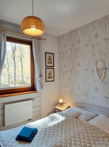 a bedroom with a bed with a blue towel on it at Willa Widok in Szczyrk
