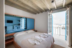 a bedroom with a bed and a large window at White Pearl Mykonos in Mikonos