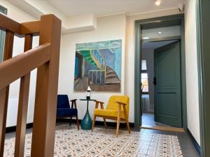a hallway with a green door and a yellow chair at ToRUŃ ApartHotel z widokiem na Wisłę i Krzywą Wieżę in Toruń
