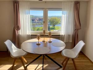 a dining room table with two chairs and a window at Das Ferienhaus mit Aussicht in Pirna