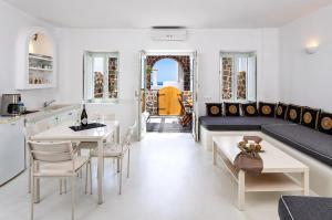 a living room with a table and chairs and a couch at Abrazo Villas in Imerovigli