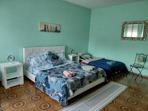 ein blaues Schlafzimmer mit zwei Betten und einem Spiegel in der Unterkunft Apartment Lago e Natura in Sandra